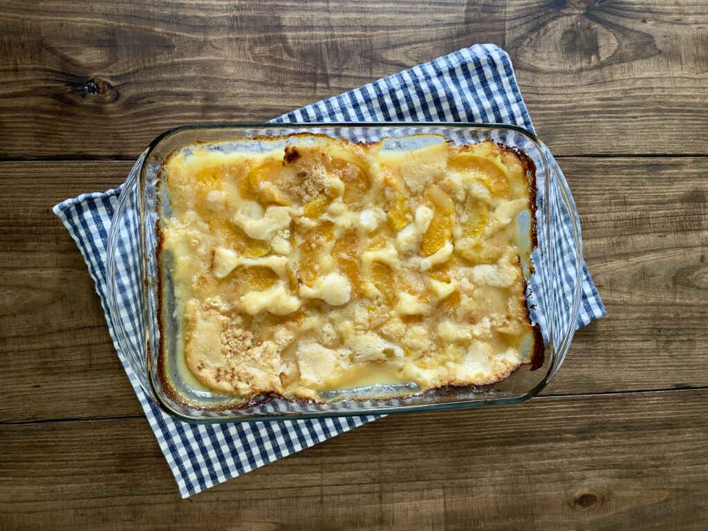 peach cobbler on blue checkered towel on wooden table